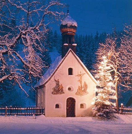 A Christmas tree aglow beside a tiny chapel in Germany's Karwendel mountains.