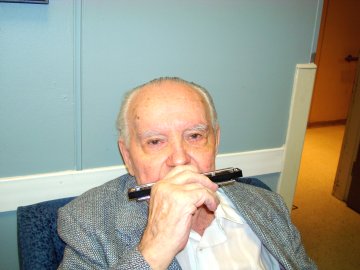 Stanley Filip No. 6, age 94, playing harmonica for fans after performance