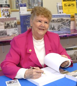 Kathleen Hicks signs a copy of her new book Streetsville: From Timothy to Hazel for James Kinder during a book signing at the Streetsville library. Photo by Claudio Cugliari from http://www.mississauga.com/article/22373