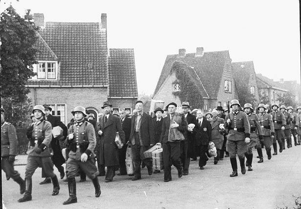 Camp prisoners marching through the streets of Amersfoort with SS guards, circa 1942.